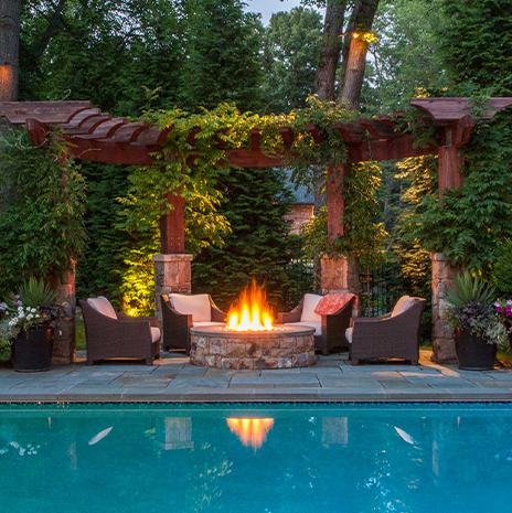 Fire Place in Backyard with Pool and Outdoor Wicker Furniture