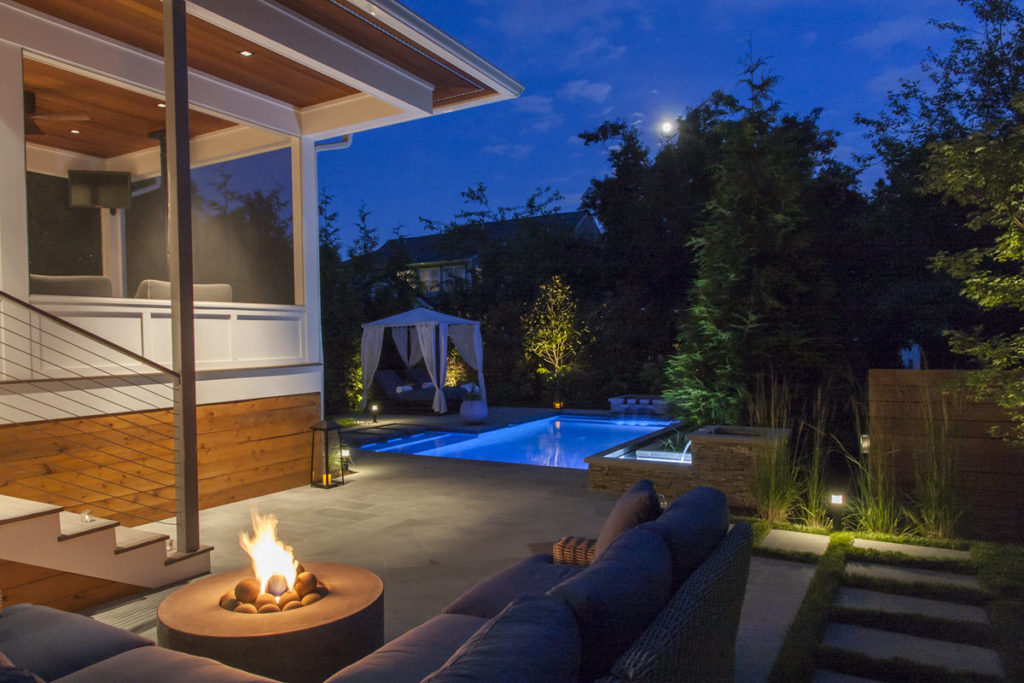 Custom-built backyard patio & pool area with fire pit and outdoor sofas.