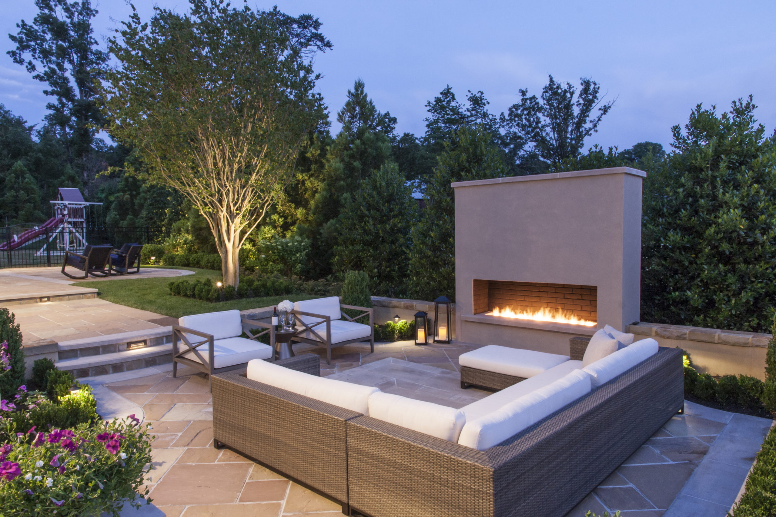 Custom outdoor fireplace surrounded by patio furniture
