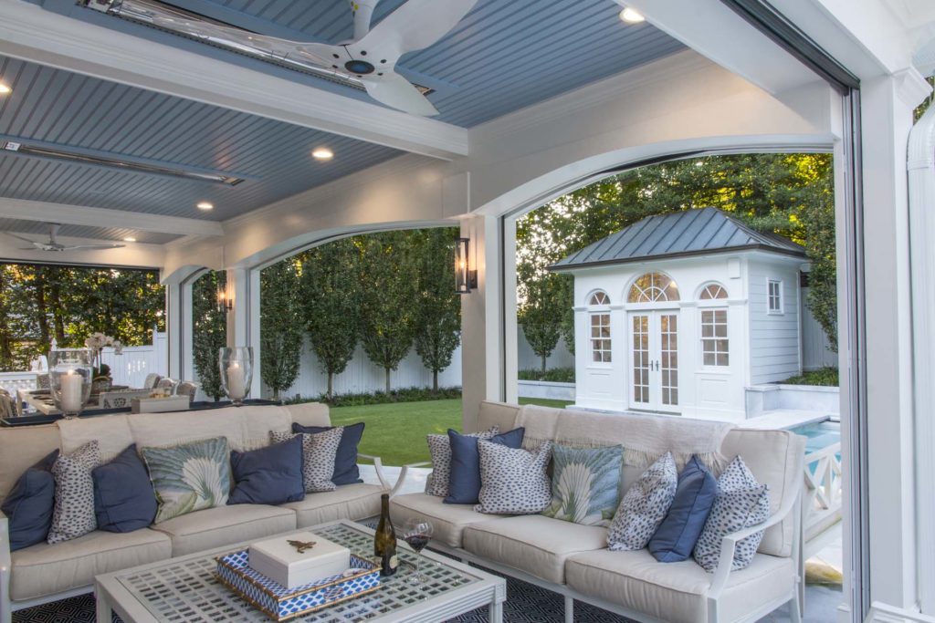 Covered patio with lighting and outdoor patio furniture with blue accent pillows