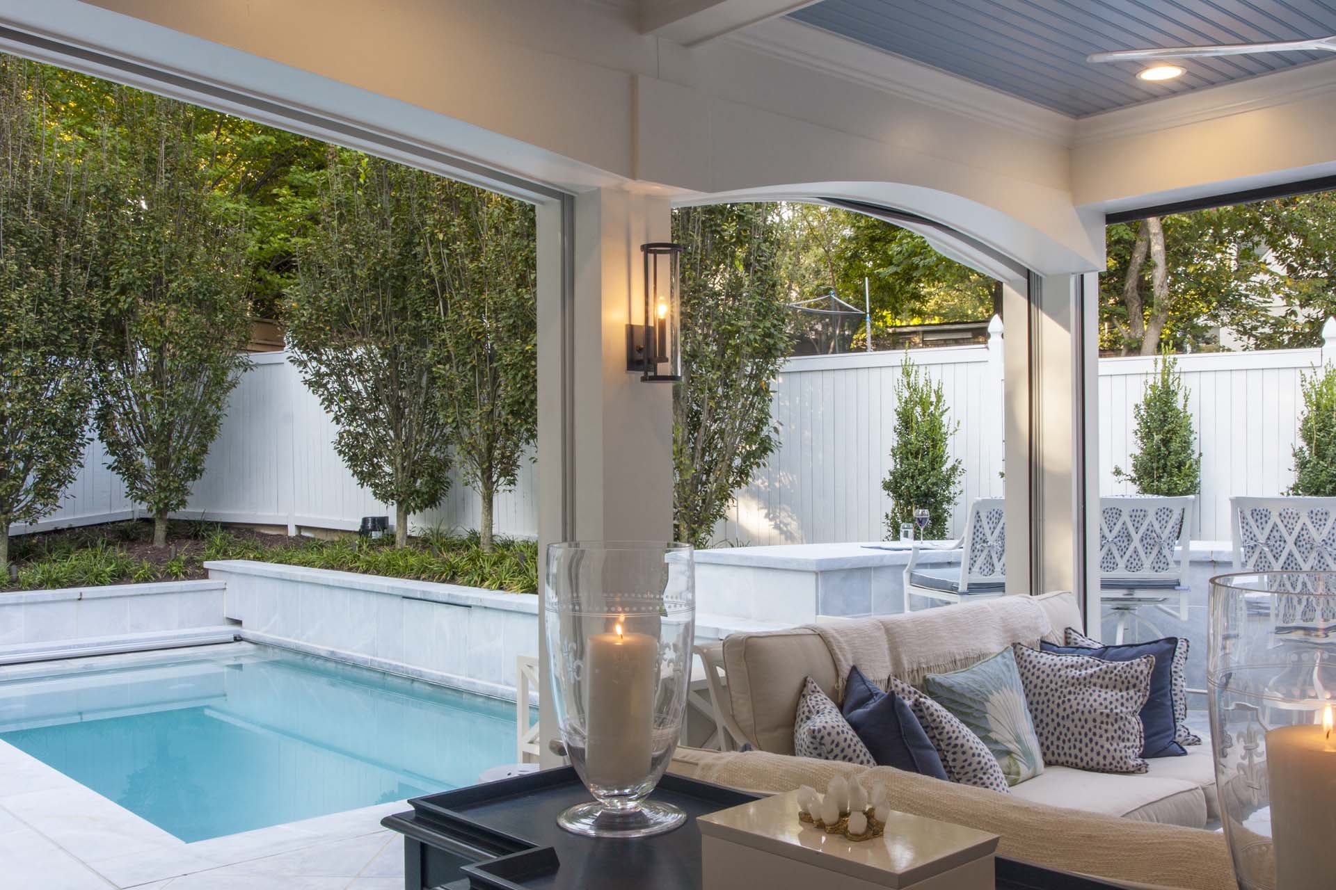 A picturesque outdoor space with a hot tub and patio furniture, bordered by a beautiful stone wall.