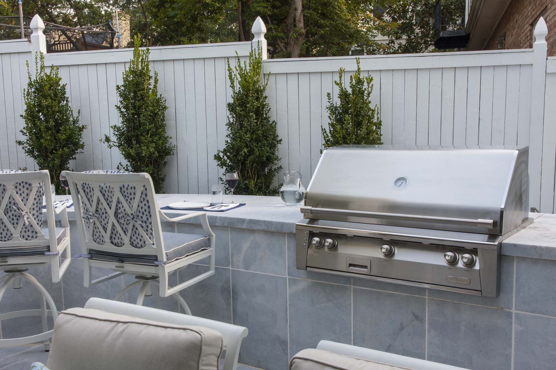 Outdoor Grill with Chairs in Backyard