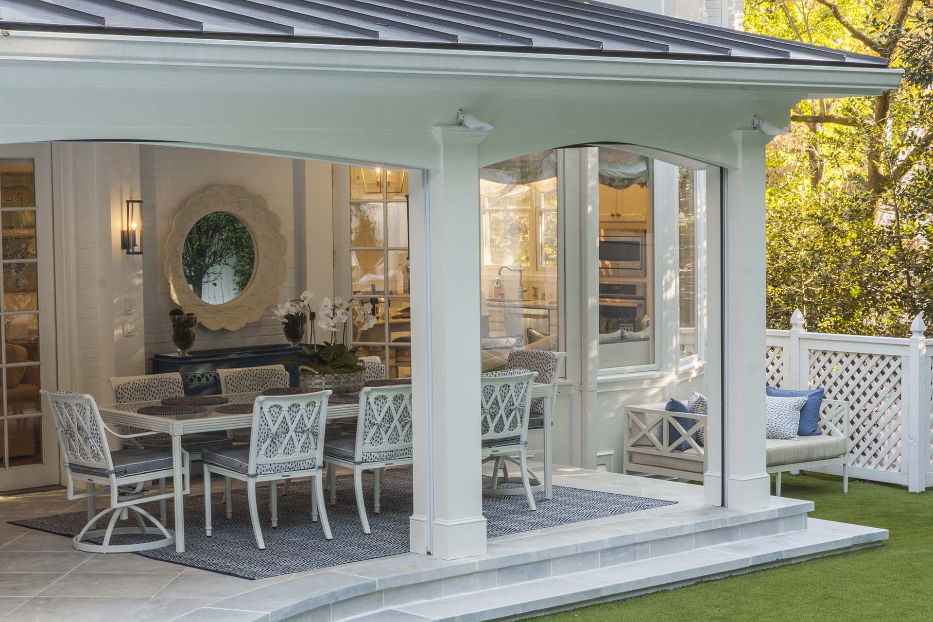 A modern swimming pool with a sleek design, surrounded by lush greenery, lounge chairs, and a firepit.