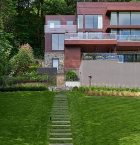 A flawlessly manicured front yard displaying exquisite landscaping.