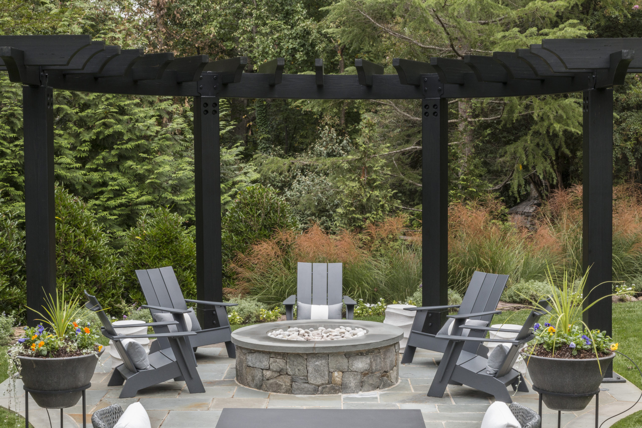 Enjoy the outdoors: a fire pit and chairs on a beautifully landscaped patio, ideal for unwinding.