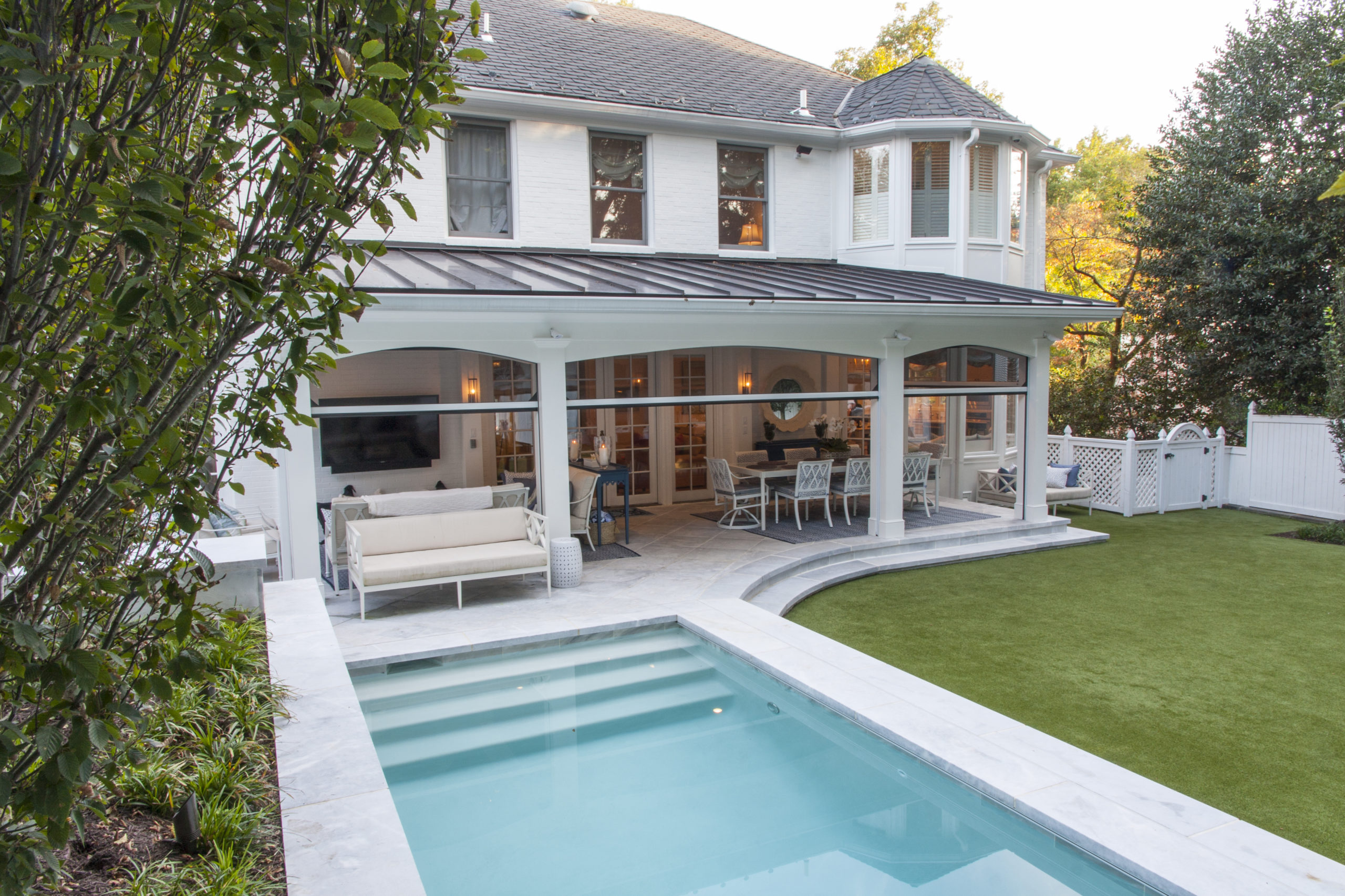 A white house with a stunning pool and patio area, exuding luxury and elegance.