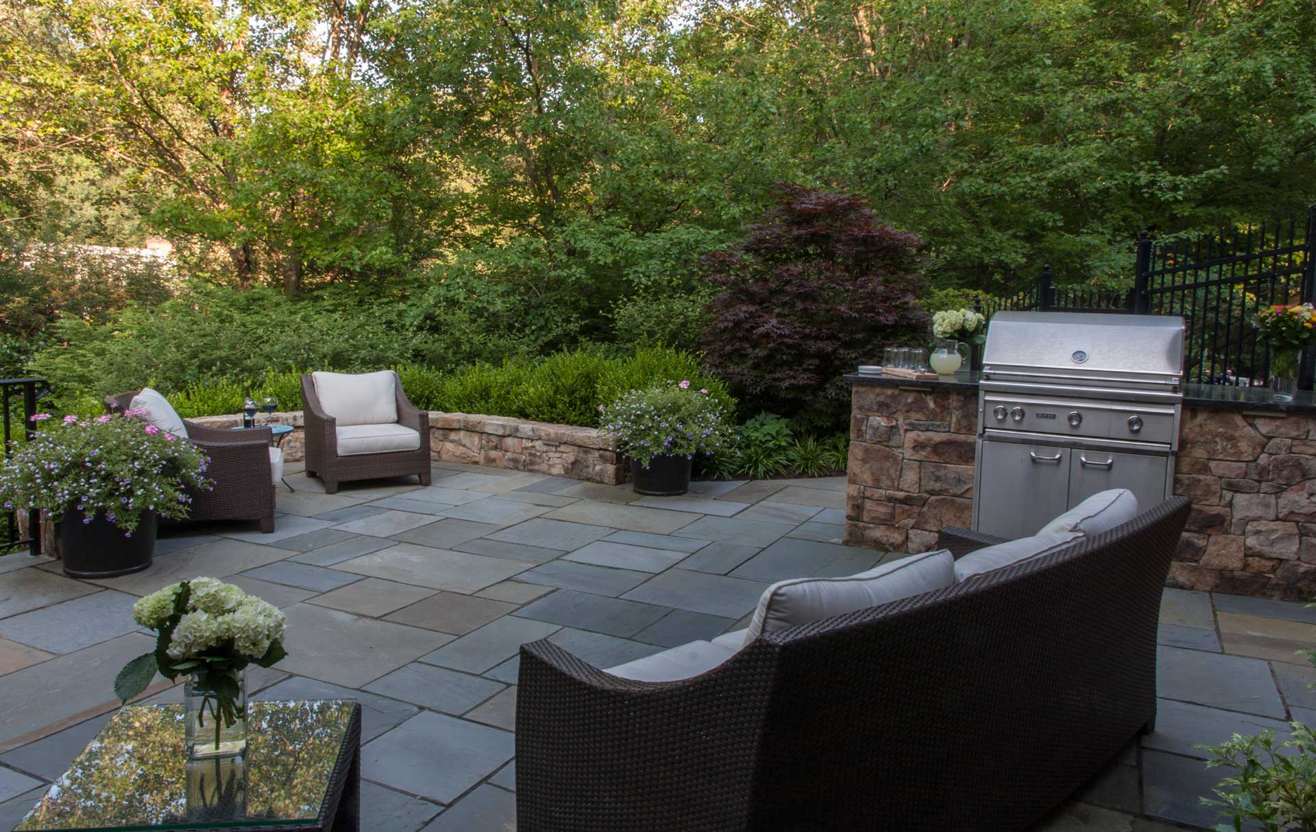 A serene garden with rustic wooden benches and vibrant green landscaping.