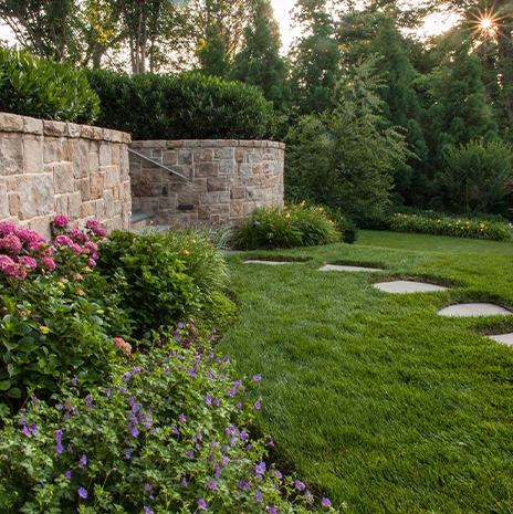 Yard Landscaping with Bushes, Flowers, and Stone Pathway