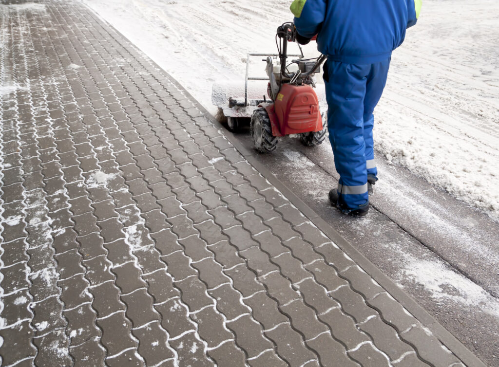 Professional snow removal person using equipment to remove snow from the ground.