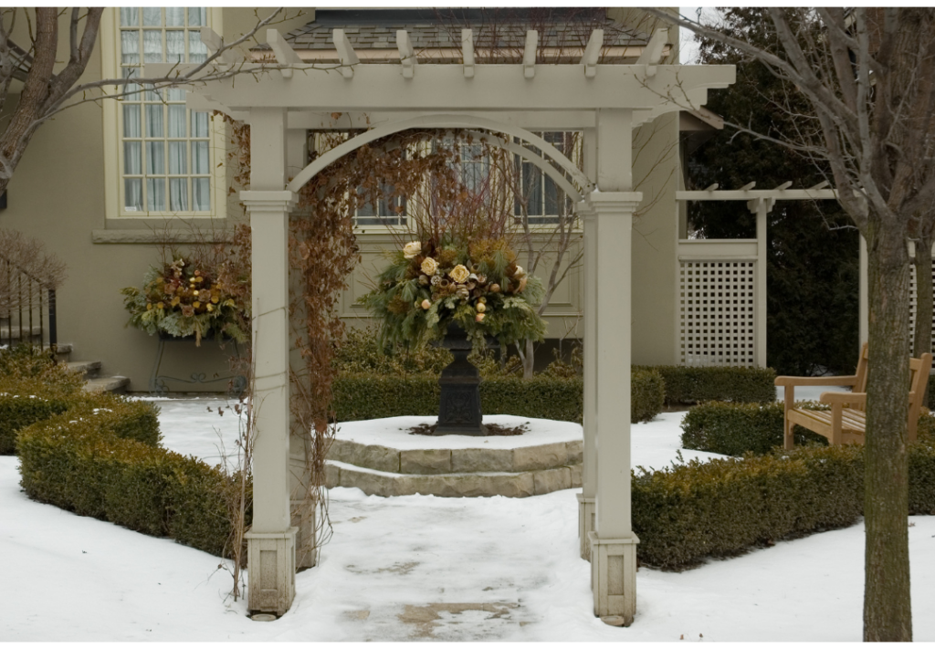 Outdoor winter garden with entryway and snow on the ground.