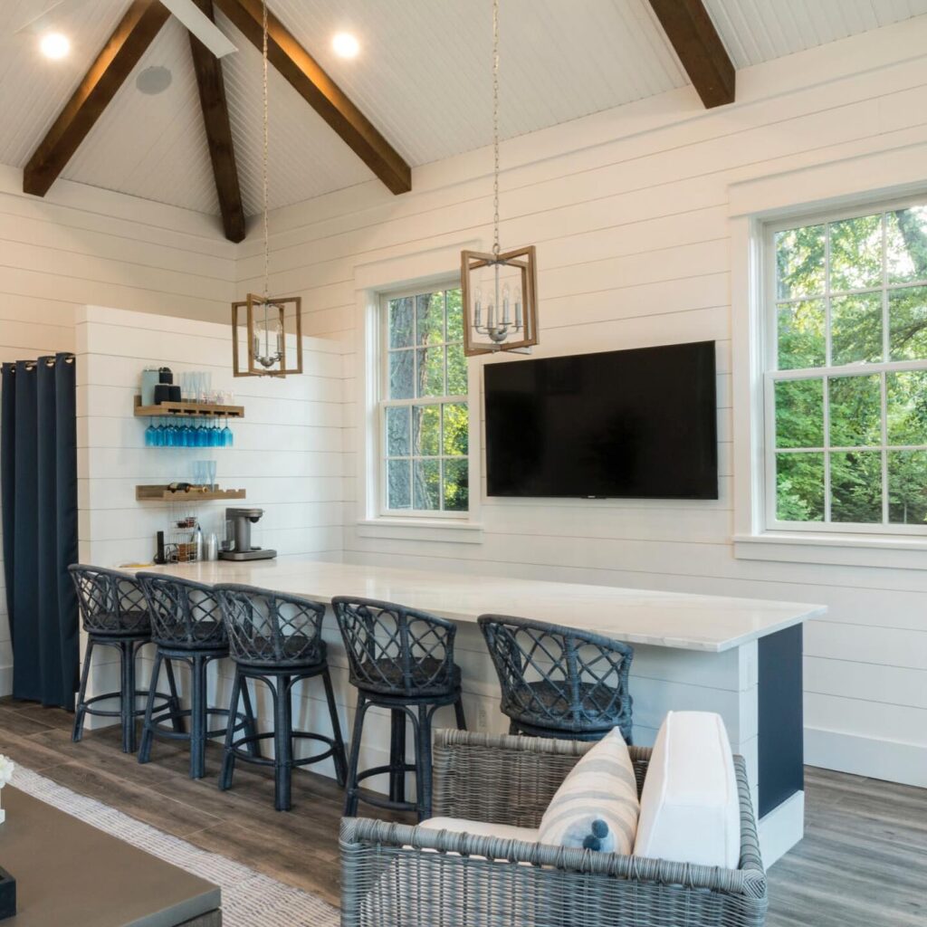 Custom pool house by Wheat's with large island, tv, and ceiling fan