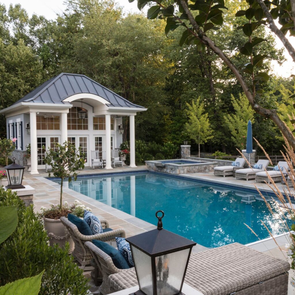 Custom pol house with arch entry behind large pool
