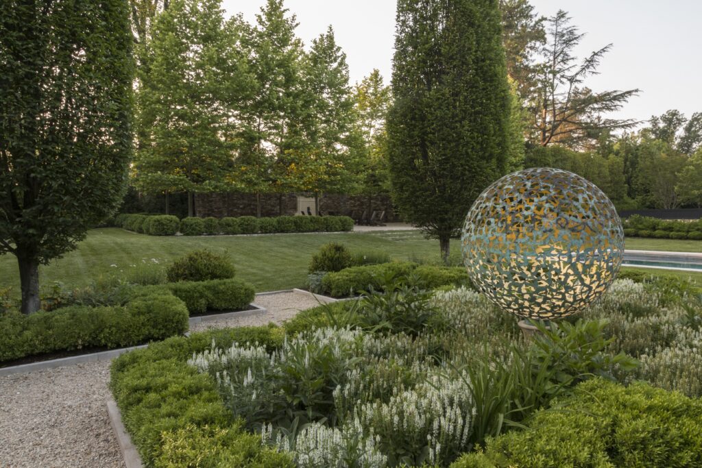 A beautifully manicured outdoor pathway with an outdoor sculpture