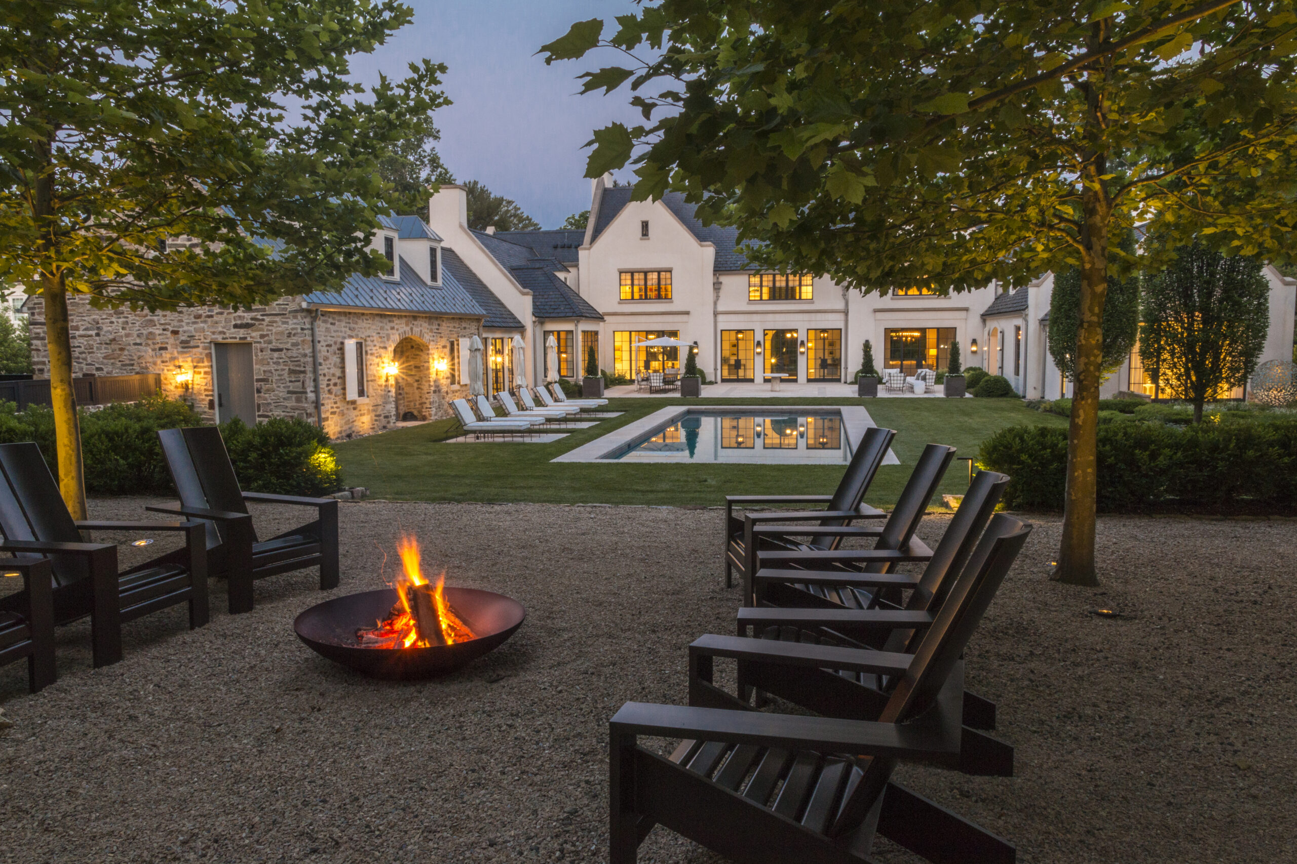 Outdoor patio area with well-manicured lawn, firepit, and pool